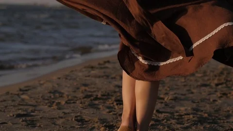 Woman dancing against the backdrop of the sunset sea. skirt close up, cloth in Vídeo Stock 104078435