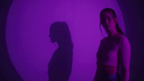 Woman Dancing and Looking At Camera in purple Studio Lighting 库存影片 259147404