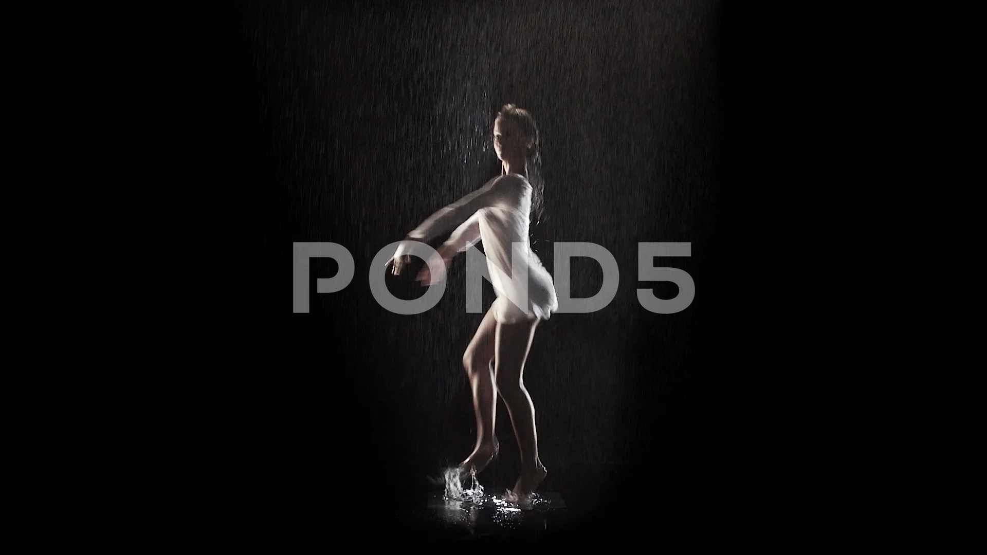 woman dancing and rotating under the rain with black background and  backlight