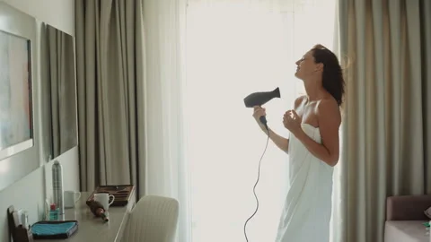 Woman dancing and singing using hair dryer Stock-Footage 104919875
