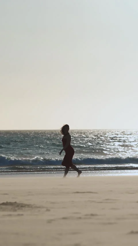 Woman dancing on the beach at sunset Stock Footage 329784685