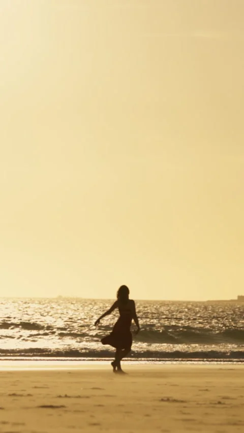 Woman dancing on the beach at sunset Stock Footage 329785976