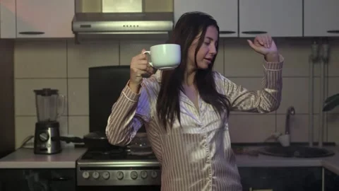 Woman dancing drinking coffee or tea at home happy evening active joyful female Stock-Footage 307785904