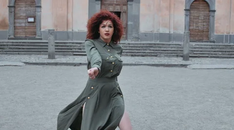 Woman dancing in an empty square in front of a church Stock-Footage 53127768