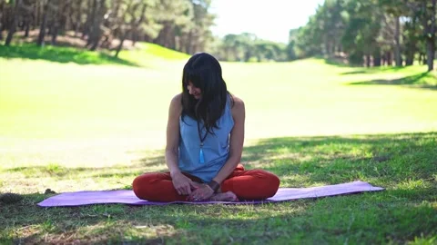 Woman dancing fluidly while seated on a yoga mat during expressive movement Stock Footage 319591644