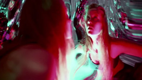Woman Dancing in front of Distorting Mirror in Vibrant Neon Lights Stock Footage 306981817
