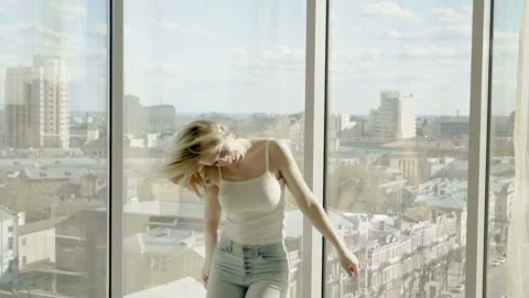 Woman dancing in front of panoramic window at a luxury hotel. Slow motion. HD Stock-Footage 104077852