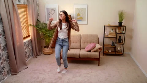 Woman Dancing Happily Across Cozy Living Room At Home Enjoying Freedom Weekend Stock Footage 147004053