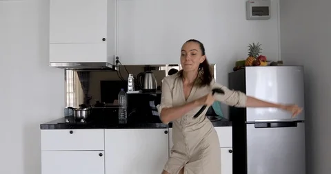 Woman dancing in kitchen Stock Footage 104389337