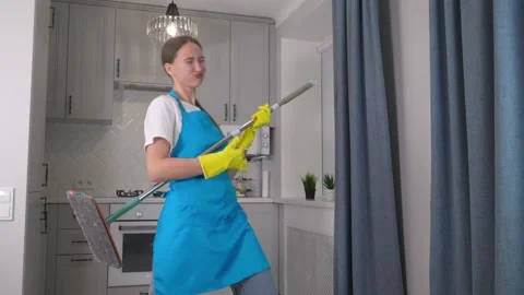 Woman dancing in kitchen. She pretends playing on guitar. holds mop in his hands 스톡 동영상 231326039