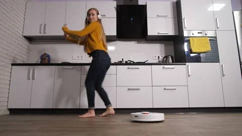 Woman dancing in kitchen while robot cleaning Stock-Footage 145018729