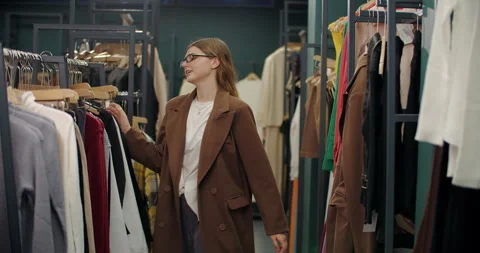 Woman dancing while choosing clothes in fashion store Stock Footage 321838859