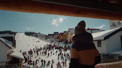 Woman dancing while standing on winter resort balcony looking the tourists. Stock Footage 299636221