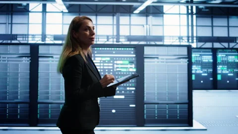 Woman in data center making sure rigs are functioning optimally 動画素材 277652211