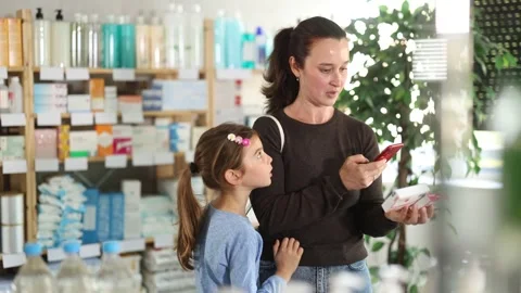 Woman with daughter scanning qr code of paracetamol Stock Footage 332637574