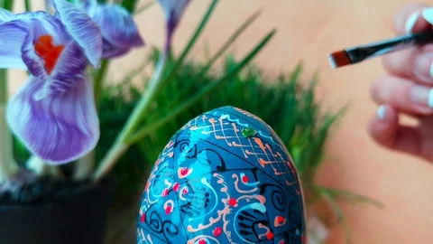Woman is decorating blue easter egg Stock Footage 103848578