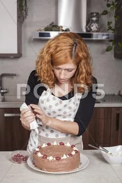 Woman Decorating Cake At Home