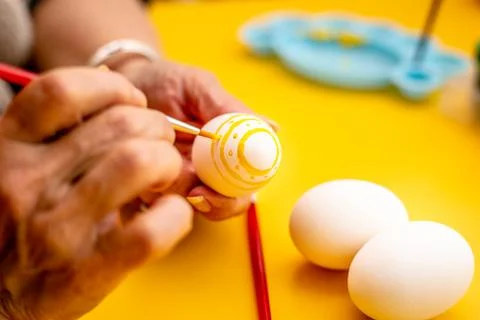 Woman decorating a easter eggs with dots and lines. Foto stock