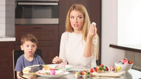 Woman Decorating Easter Eggs with Little Son Stock Footage 103962402