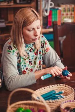 Woman decorating the Easter eggs by scratching patterns on dyed eggs Stock Photos