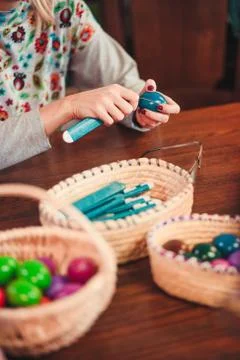 Woman decorating the Easter eggs by scratching patterns on dyed eggs Stock Photos