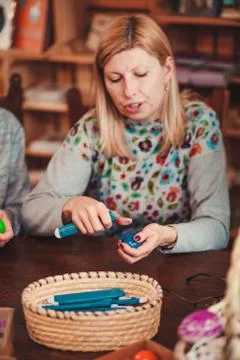 Woman decorating the Easter eggs by scratching patterns on dyed eggs Stock Photos