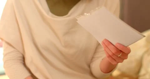 A woman is deeply reading a personal note with great focus in a cozy setting 스톡 동영상 329281758