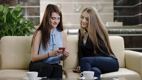 Woman demonstrating display of the phone to friend Stock Footage