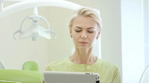 Woman dentist using tablet computer. Dental professional using tablet pc Vídeos de archivo 97470959