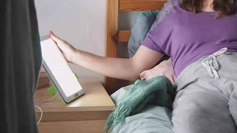 Woman depressed by winter using light therapy lamp for mental health care Stock Footage 222000470