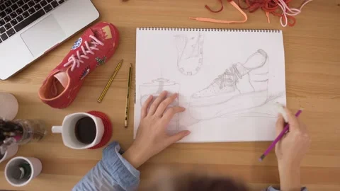 Woman designer using rubber to correct mistakes on fashion sketch Stock Footage 133281922