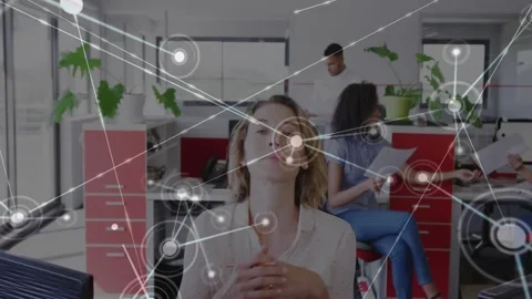 Woman at desk tapping screen, looking up, clasping as node overlay expanding, Stock Footage 333902490
