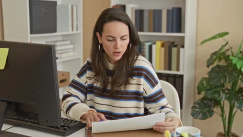 Woman at desk typing on computer while holding papers and tapping a pen, lo.. Stock Footage 339245162