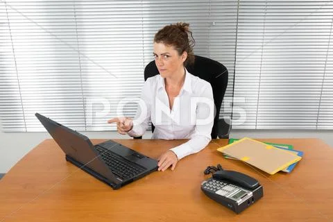 Woman At Desk Working On Her Laptop