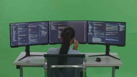 Woman Developer Talking On Mobile Phone While Write Code With Multiple Computer Stock Footage 252564658