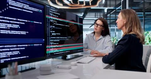 Woman Developer Uses A Computer To Review And Merge Code Changes. Stock Photos
