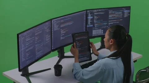 Woman Developer Working With Tablet While Write Code With Multiple Computer Stock Footage 252577817