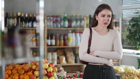 Woman develops stomach ache while grocery shopping Video stock 310320243