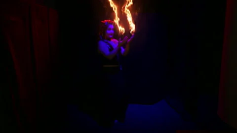 Woman devil dancing with fiery streams on her hands on a black background. 動画素材 121885891