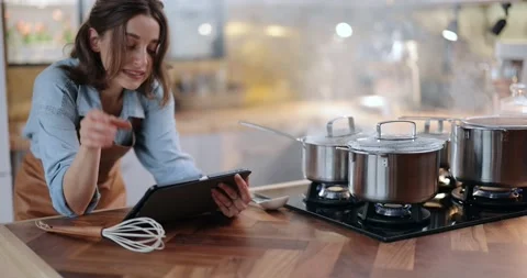 Woman with digital tablet while cooking Stock Footage 147623862