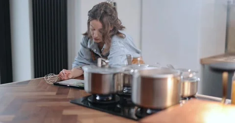 Woman with digital tablet while cooking Stock Footage 147623951
