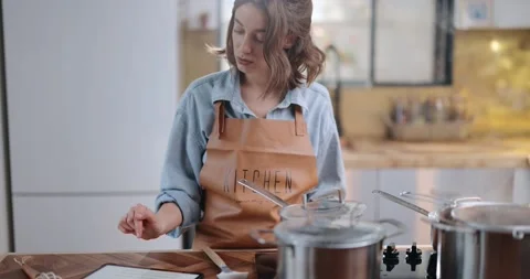 Woman with digital tablet while cooking Stock Footage 147624076