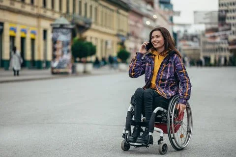 Woman with disability using a smartphone while out in the city Stock Photos