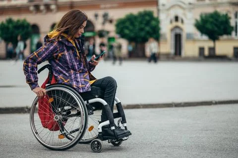 Woman with disability using a smartphone while out in the city Stock Photos