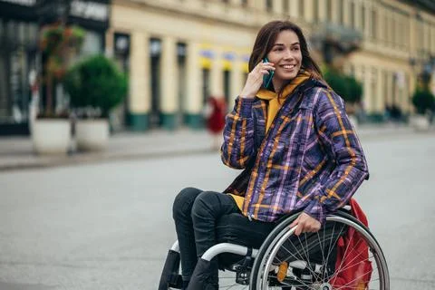 Woman with disability using a smartphone while out in the city Stock Photos