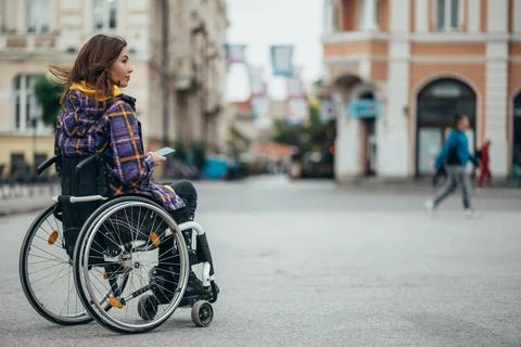 Woman with disability using a smartphone while out in the city Stock Photos