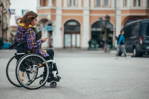 Woman with disability using a smartphone while out in the city Stock Photos