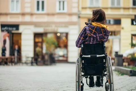 Woman with disability using a smartphone while out in the city Stock Photos