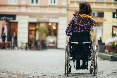 Woman with disability using a smartphone while out in the city Stock Photos