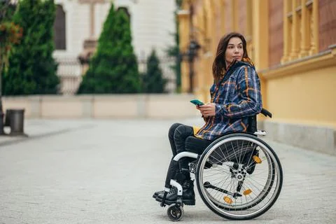 Woman with disability using a smartphone while out in the city Stock Photos